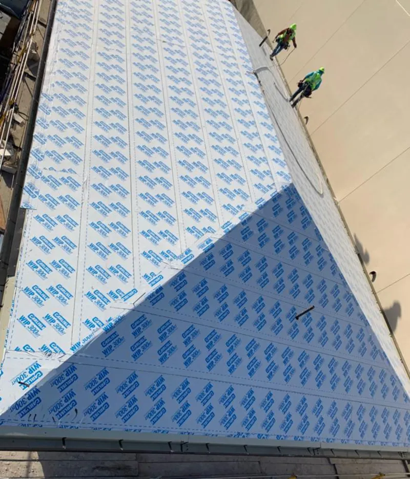 Professional roofers installing underlayment on a metal roof in Laguna Niguel